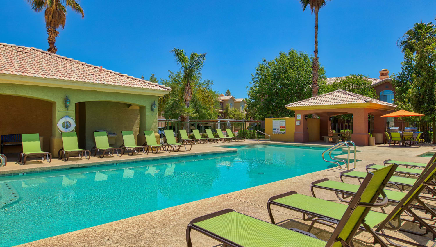 Sparkling pool with lounge chairs at Serena Shores Apartments in Gilbert, Arizona