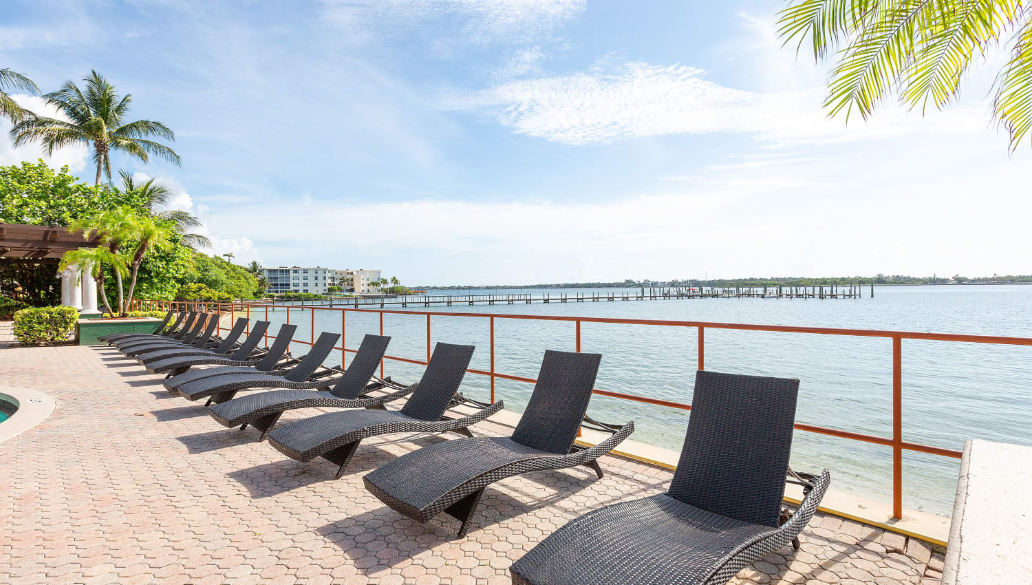 Waterfront seating by the pool at Manatee Bay Apartments in Boynton Beach, Florida