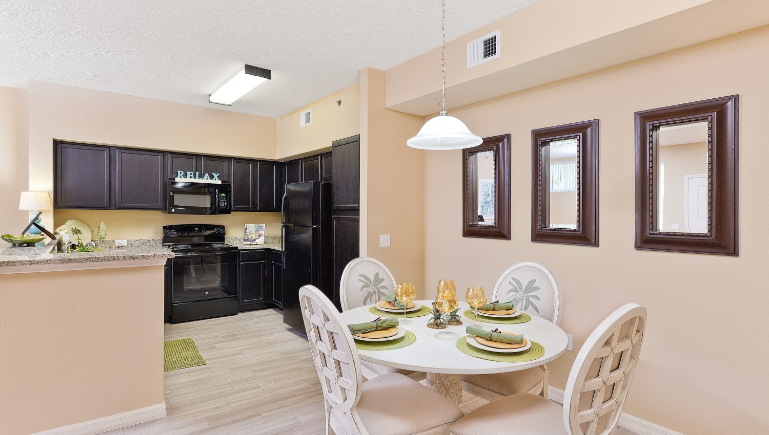 Model dining area and kitchen at Manatee Bay Apartments in Boynton Beach, Florida