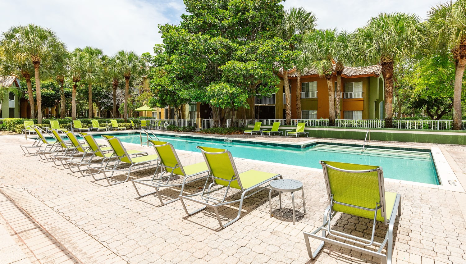 Sparkling pool and lounge chairs at Mosaic Apartments in Coral Springs, Florida