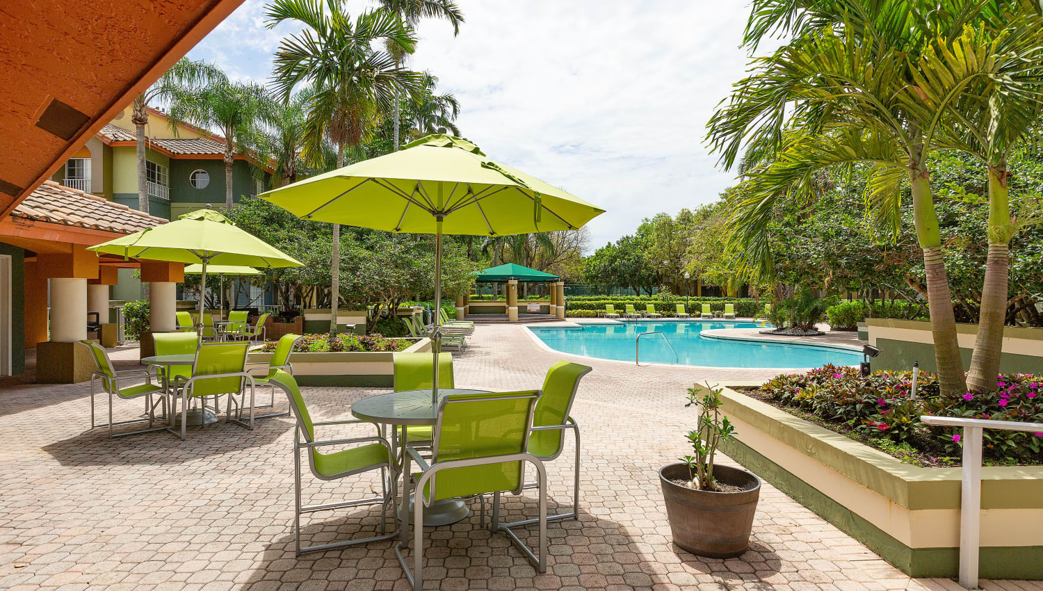 Shaded seating by the pool at Mosaic Apartments in Coral Springs, Florida