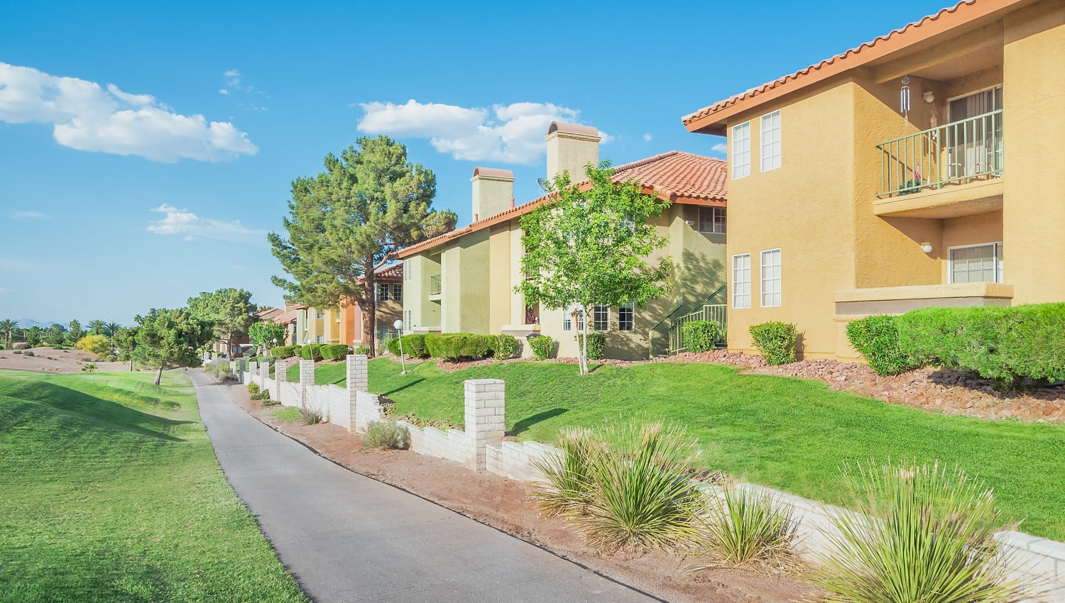 Golf course and exterior view of apartments at Invitational Apartments in Henderson, Nevada
