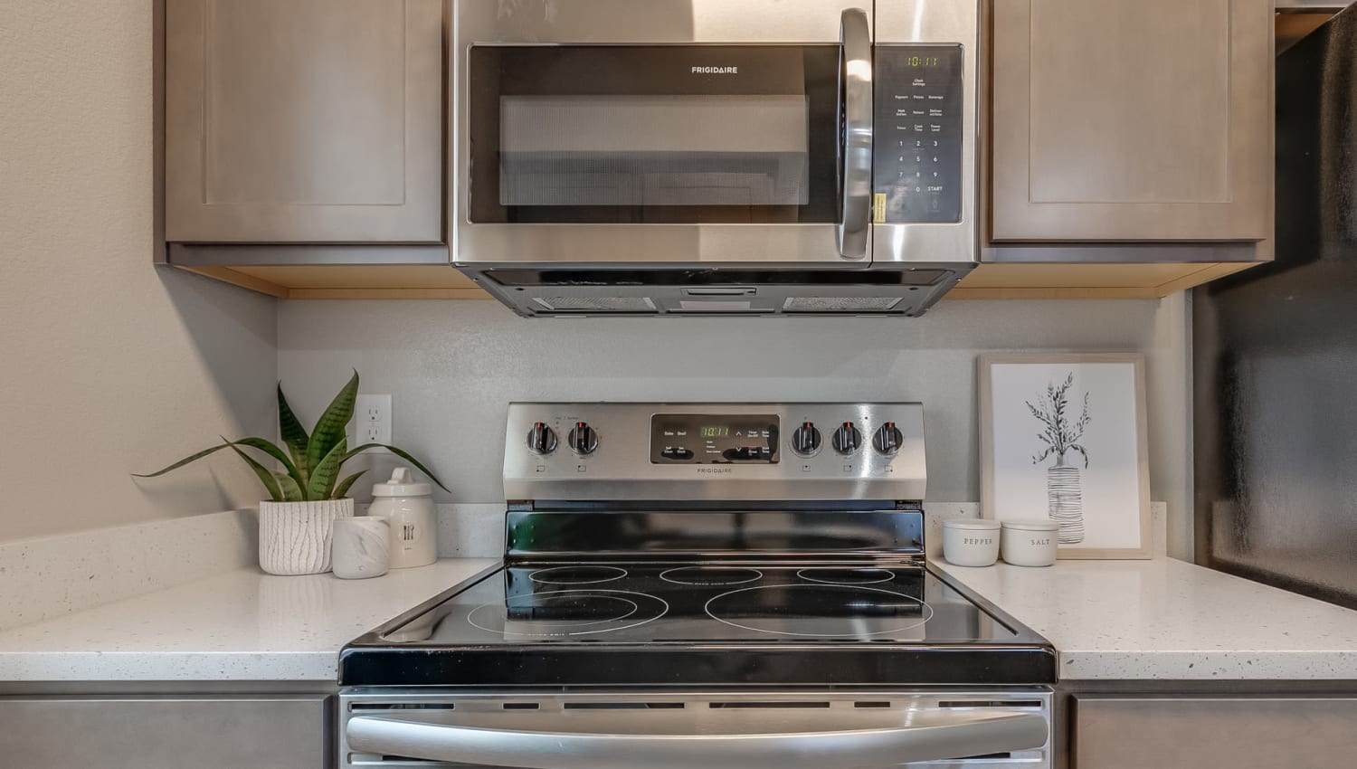 Stainless steel appliances including built-in microwave in a kitchen at Olympus at Ten Mile in Meridian, Idaho