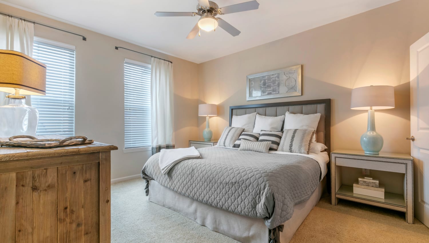 Spacious model bedroom with ceiling fan and plush carpeting at The Village at Apison Pike in Ooltewah, Tennessee