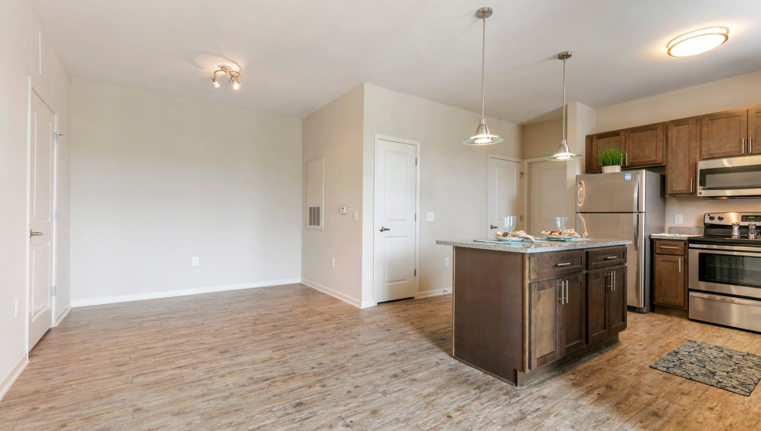 Open, modern kitchen and living room in an apartment home at The Village at Apison Pike in Ooltewah, Tennessee