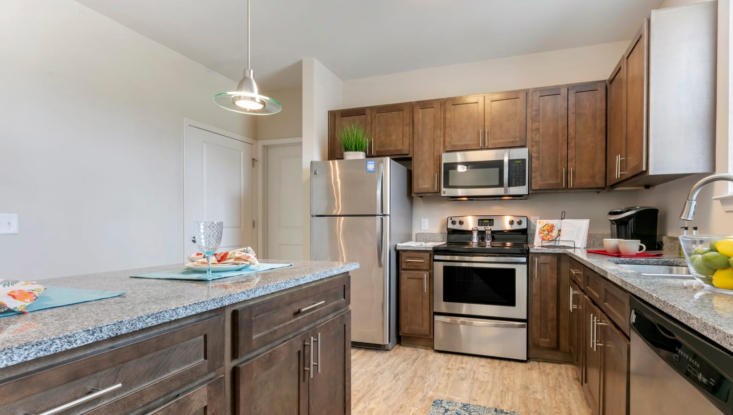 Kitchen with stainless steel appliances and granite countertops at The Village at Apison Pike in Ooltewah, Tennessee