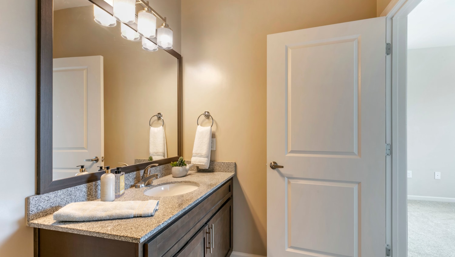 Bathroom with oversized vanity with custom cabinetry and granite countertop at The Village at Apison Pike in Ooltewah, Tennessee