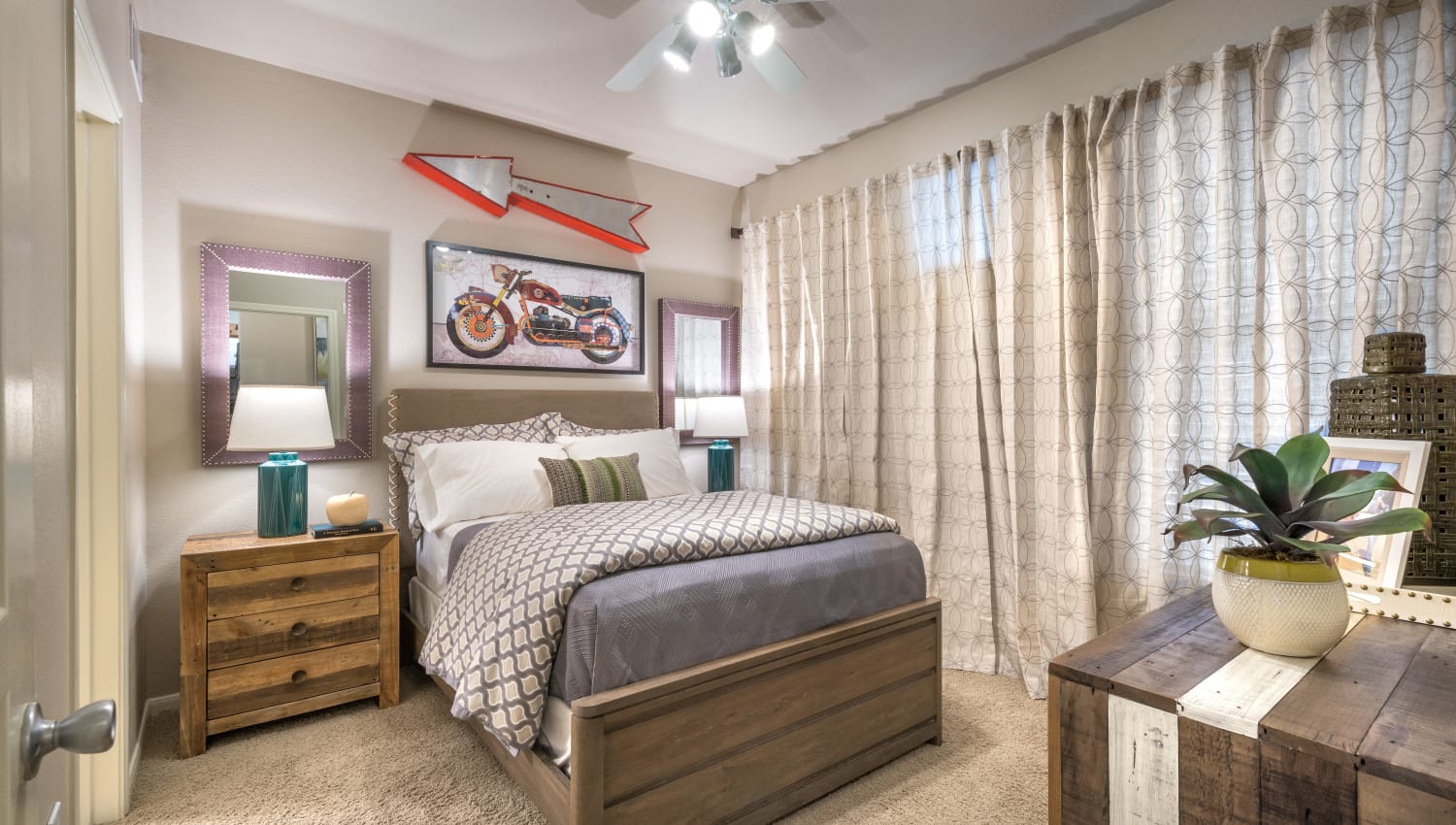 Model bedroom with plush carpeting and a ceiling fan at 75 West in Dallas, Texas