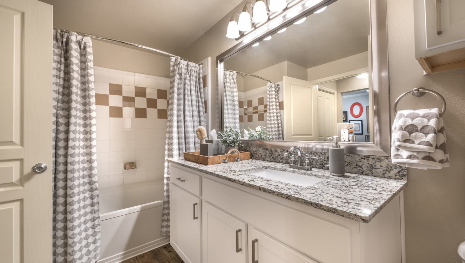Bathroom with tiled shower/tub combination and oversized vanity at 75 West in Dallas, Texas