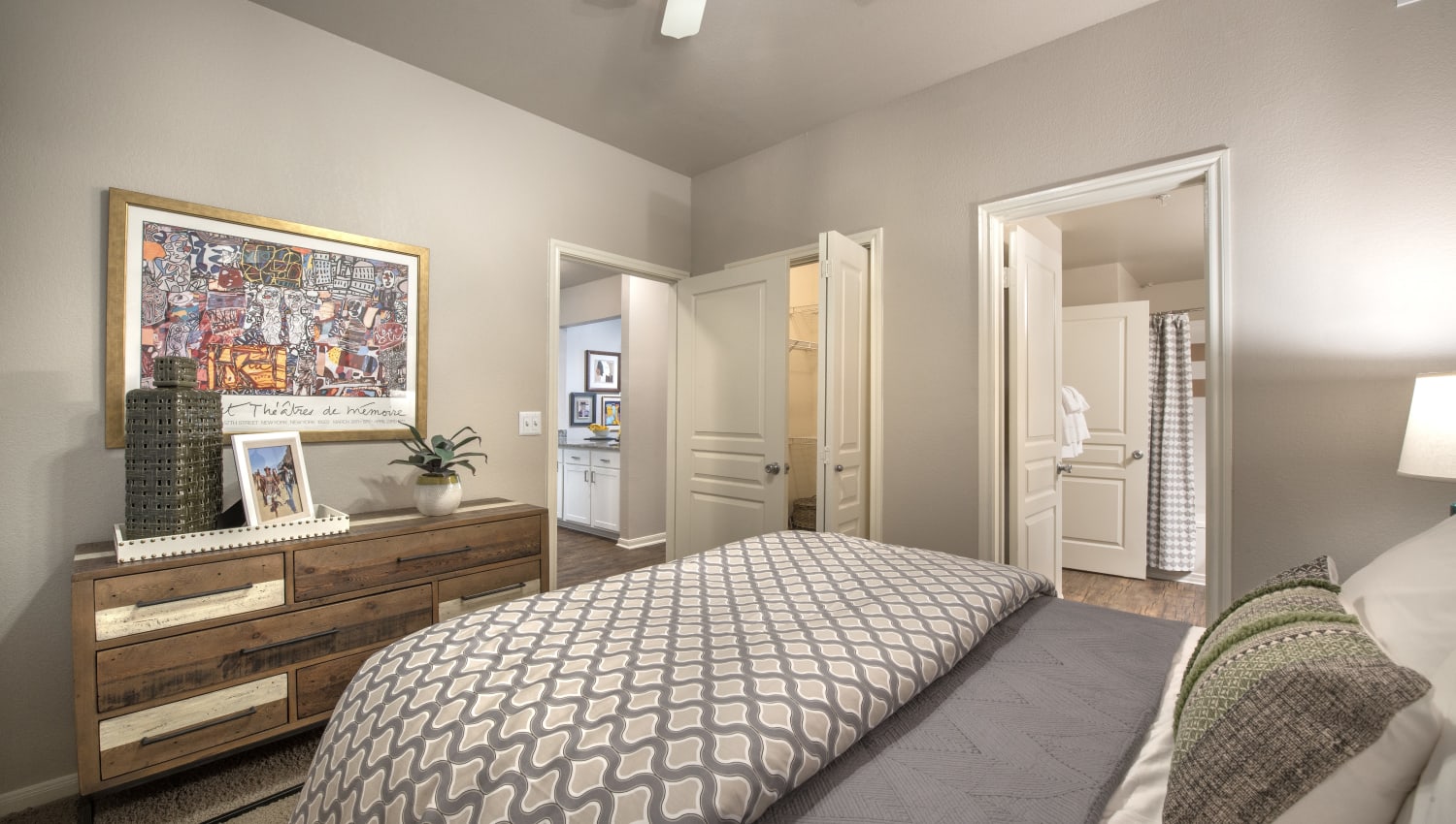 Bedroom with ensuite bathroom and  a walk-in closet in a model home at 75 West in Dallas, Texas