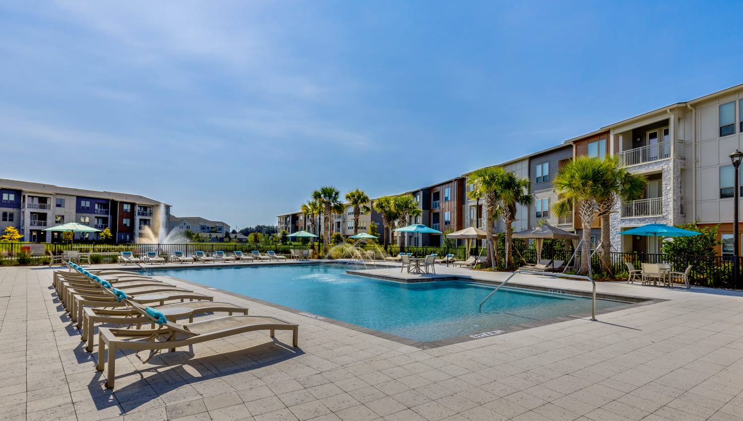 Sparkling resort-style pool with plenty of sun deck lounge chairs at The Point at Town Center in Jacksonville, Florida