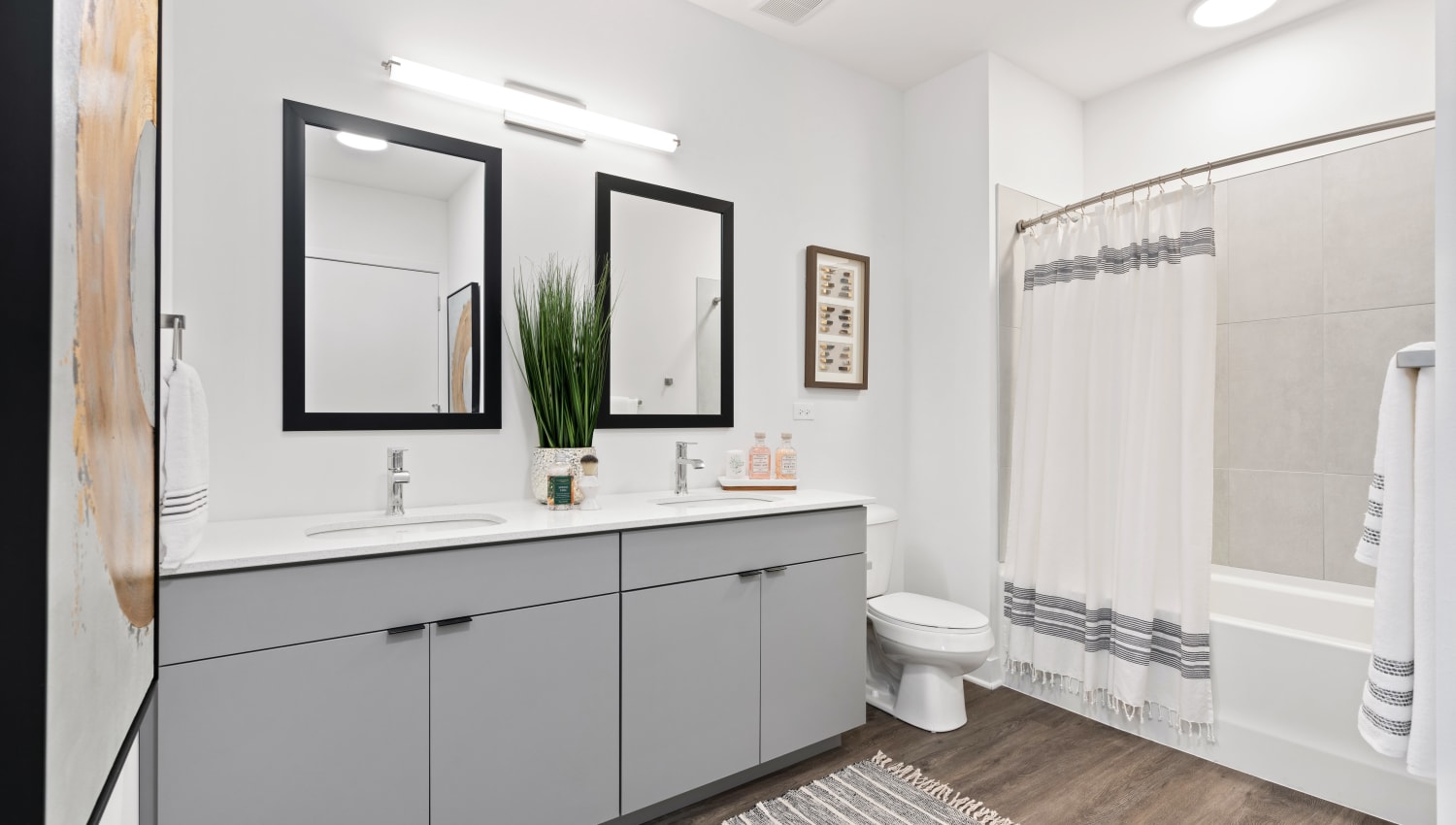 Two mirrors in the bathroom over the spacious vanity at The Residences at Sawmill Station in Morton Grove, Illinois