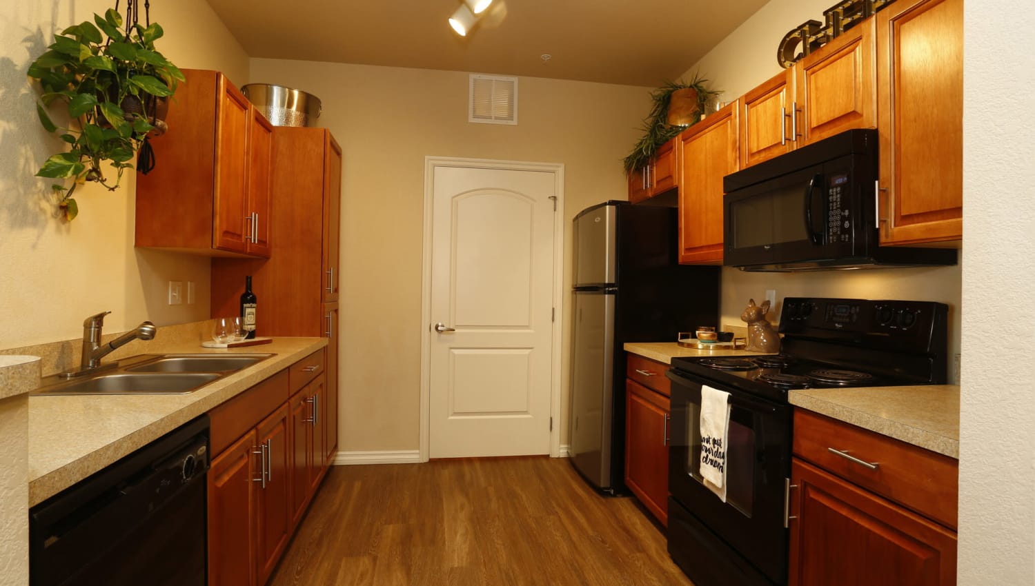 Model kitchen with wood-style flooring at The Preserve at Greenway Park in Casper, Wyoming