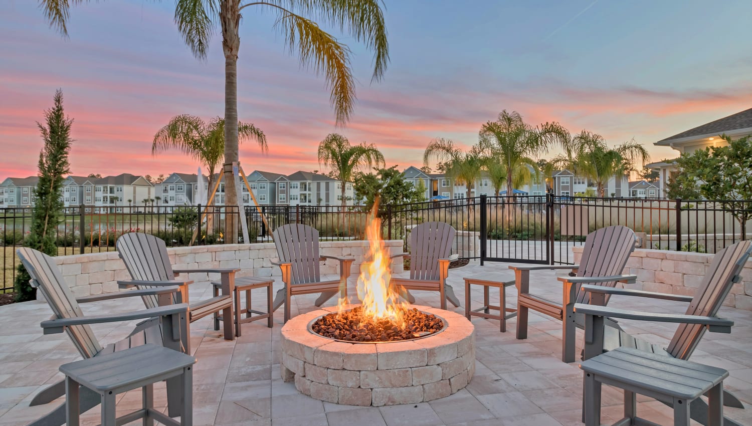 Firepit at sunset with adirondack chairs at Lakeline at Bartram Park in Jacksonville, Florida