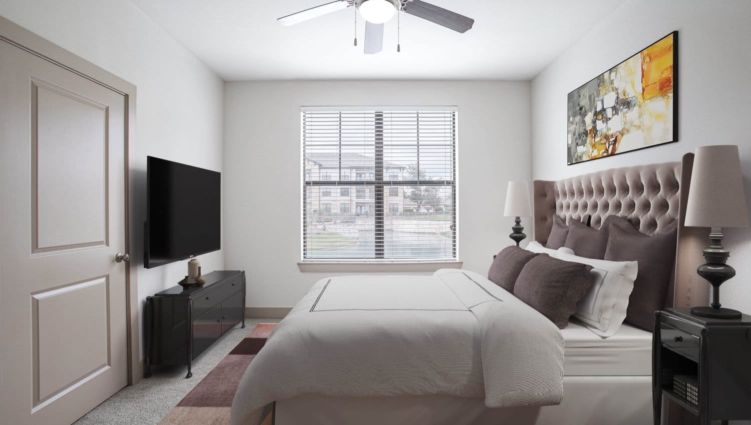 Model bedroom with TV and plenty of natural light at Olympus Falcon Landing in Katy, Texas