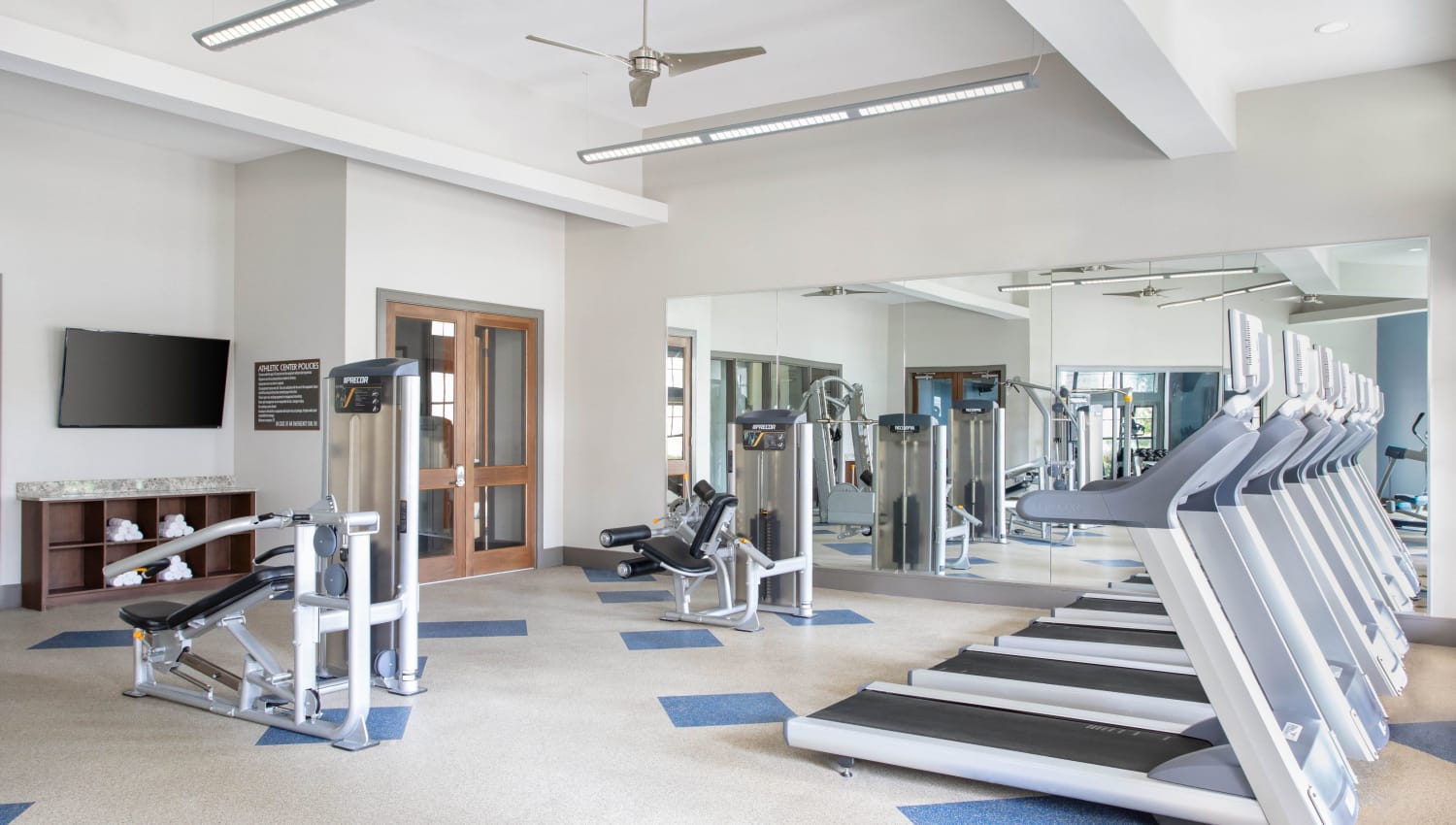 Treadmills and free weights in the gym at Olympus Falcon Landing in Katy, Texas