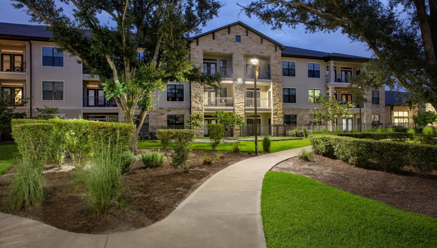 Exterior view of building and freshly cut landscape at Olympus Falcon Landing in Katy, Texas