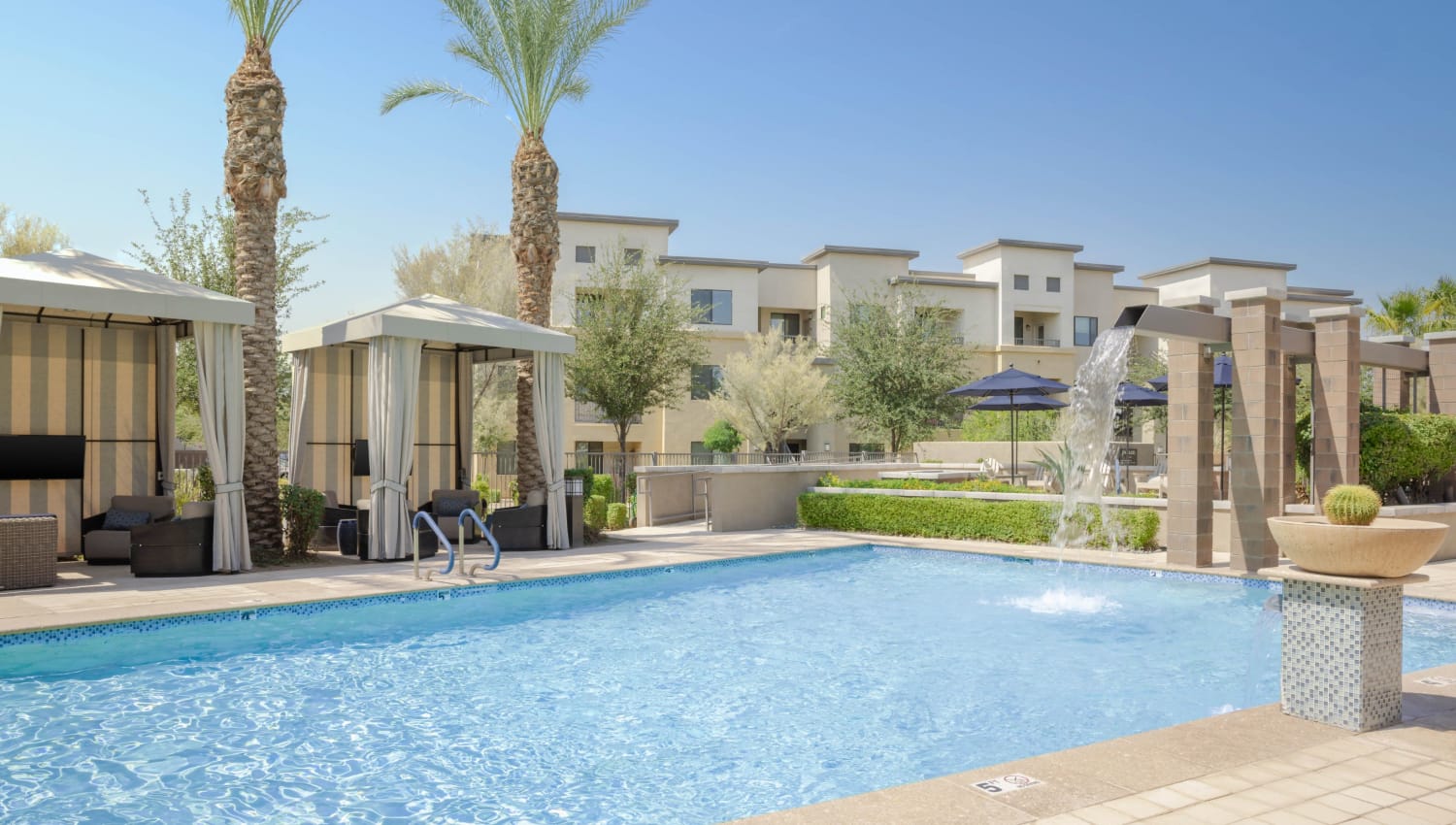 Sparkling outdoor pool with a waterfall at Cadia Crossing in Gilbert, Arizona
