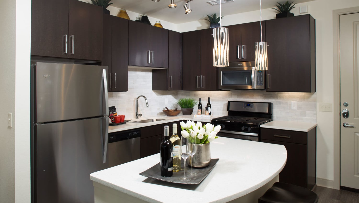 Dark cabinets and granite countertops in the kitchen at Olympus at Memorial in Houston, Texas
