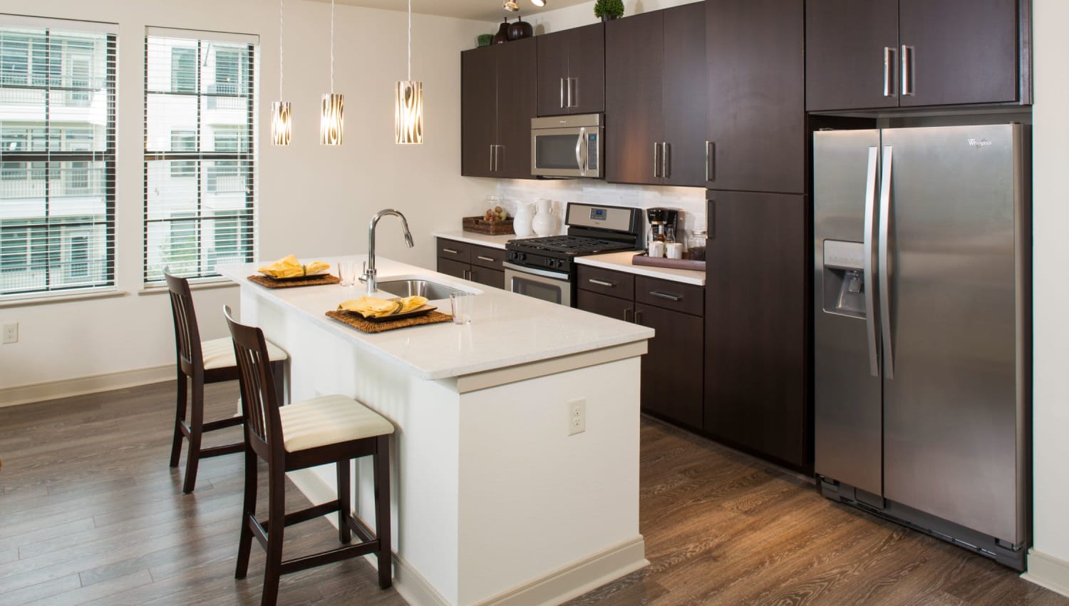 Kitchen with island and barstools at Olympus at Memorial in Houston, Texas
