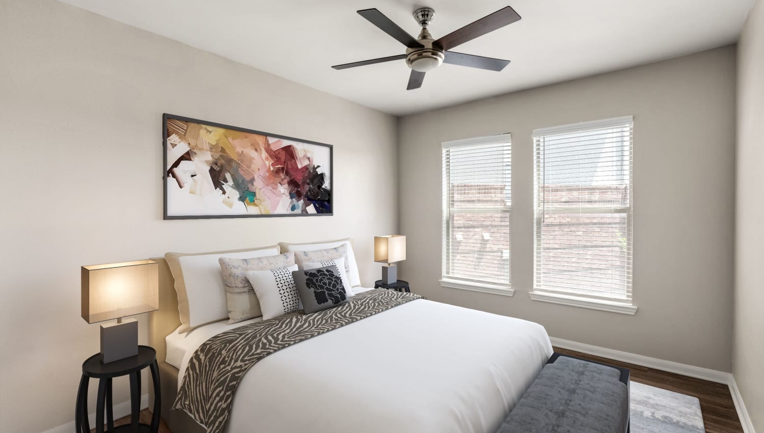 Brightly lit model bedroom with ceiling fan at Olympus Las Colinas in Irving, Texas