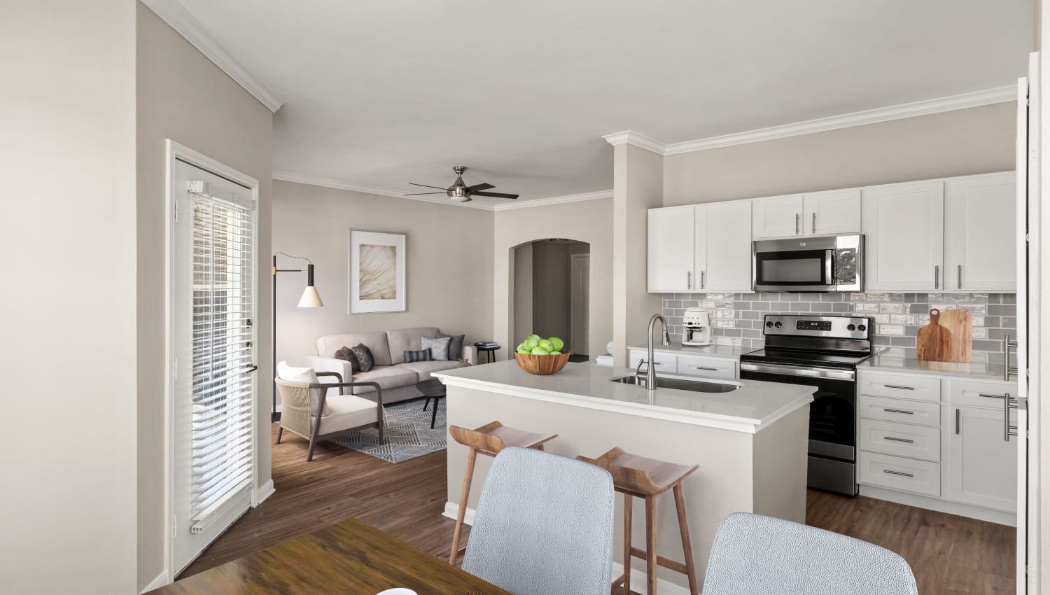 View of kitchen and living room from dining nook at Olympus Las Colinas in Irving, Texas