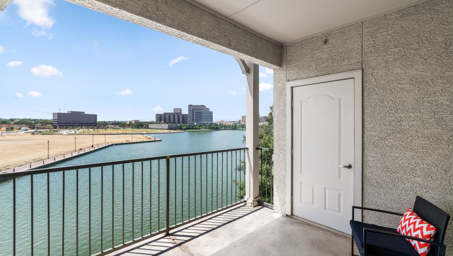 Unit porch with view of water at Olympus Las Colinas in Irving, Texas