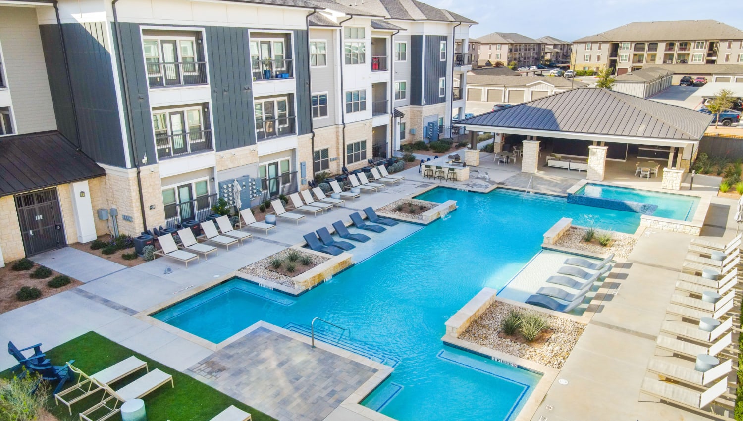 Swimming pool with pool-side seating at The Everett at Ally Village in Midland, Texas