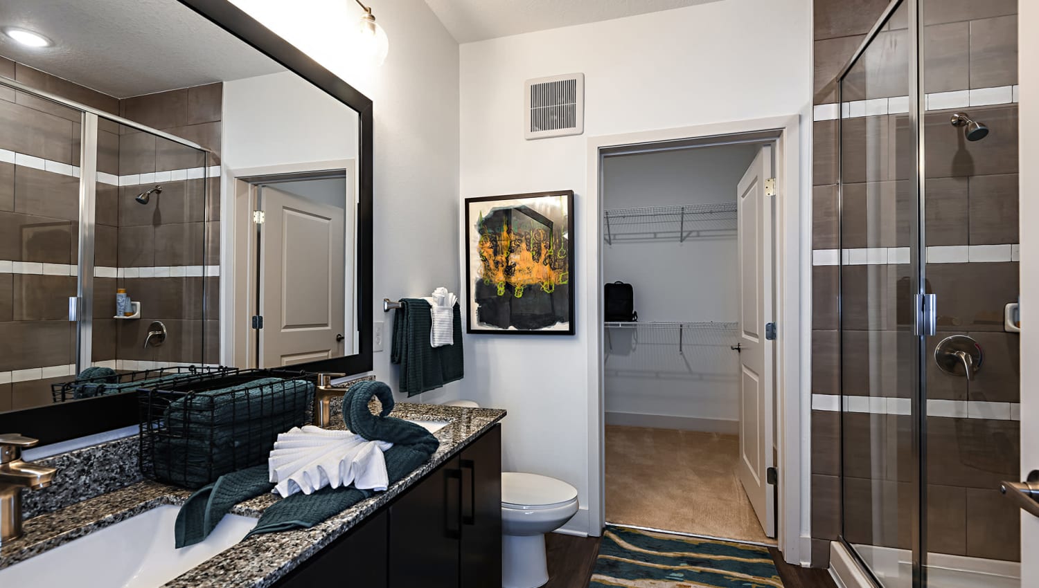 Bathroom with granite countertops and attached closet at Olympus Preserve at Town Center in Jacksonville, Florida