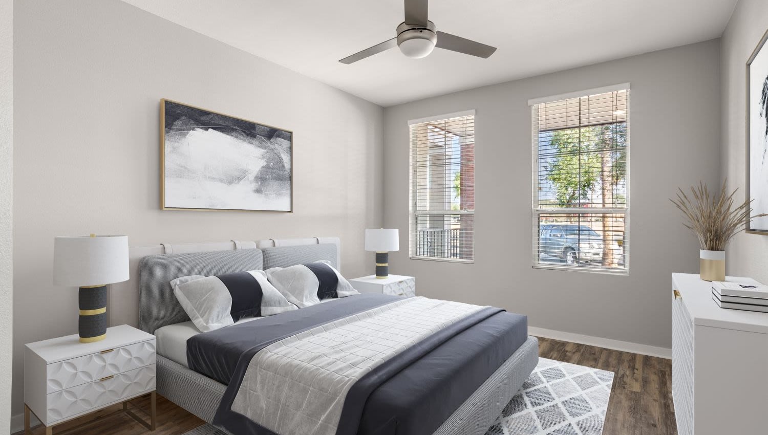 Model bedroom with plush carpeting and a ceiling fan at Town Commons in Gilbert, Arizona