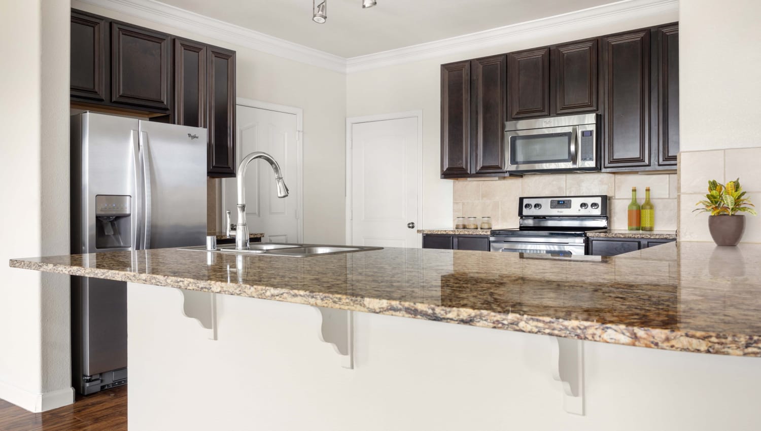 Kitchen with granite table top at Olympus Woodbridge in Sachse, Texas