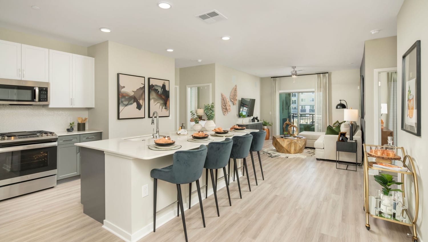 Kitchen and living room with wood-style flooring at Olympus Chandler at the Park in Chandler, Arizona
