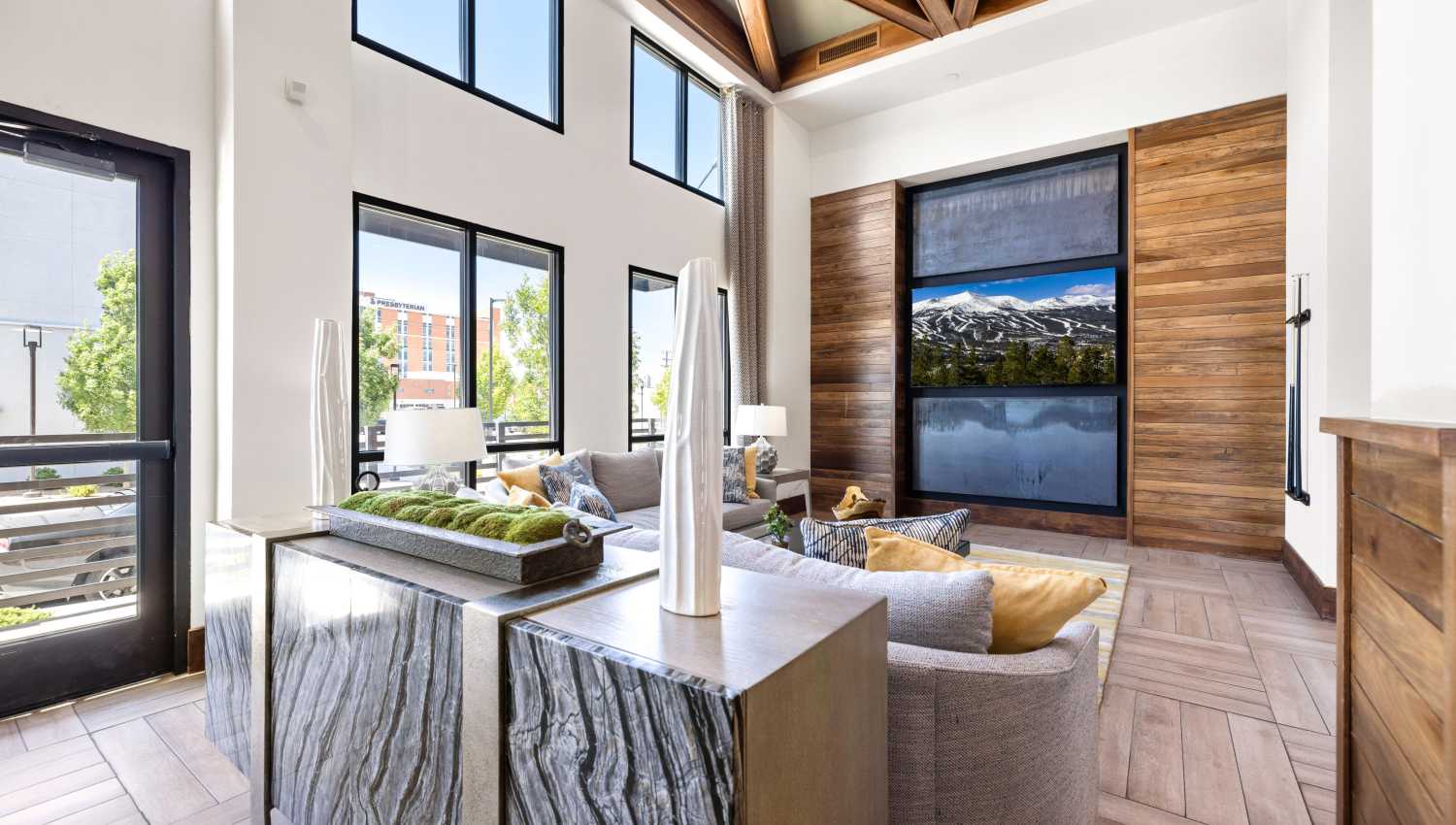 Clubhouse living room with a large television and a large window at Olympus Highlands North in Albuquerque, New Mexico