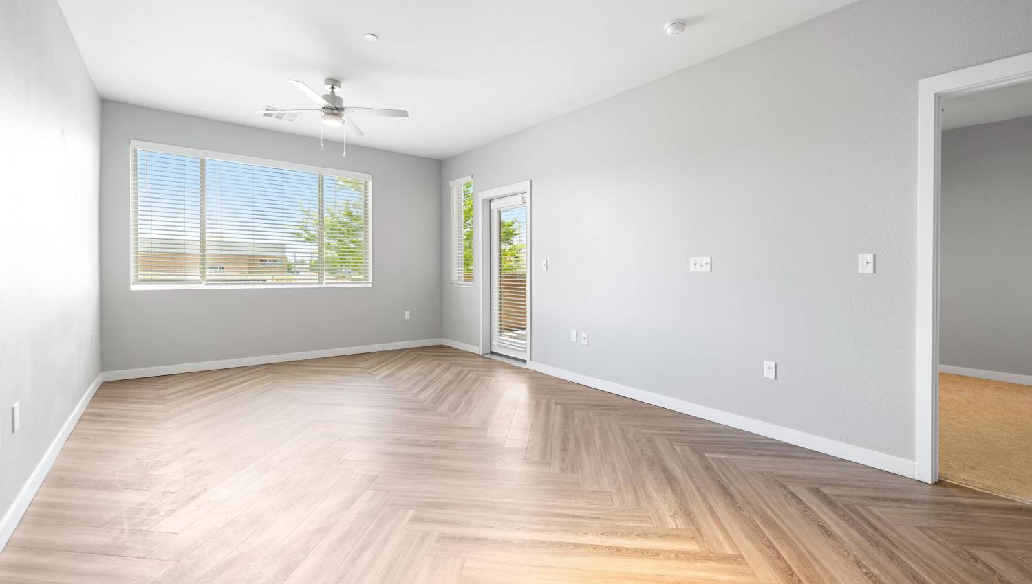 Model unit bedroom with a wood floor and a ceiling fan at Olympus Alameda in Albuquerque, New Mexico