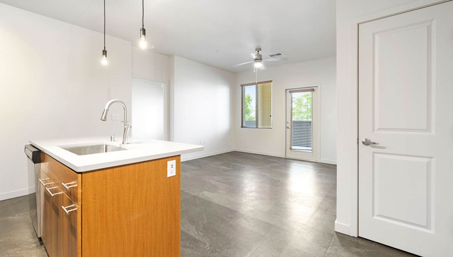 A kitchen  with a sink and living room at Olympus Alameda in Albuquerque, New Mexico
