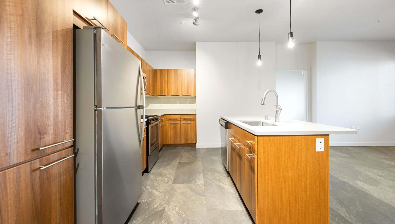 A kitchen with a stainless steel refrigerator at Olympus Alameda in Albuquerque, New Mexico