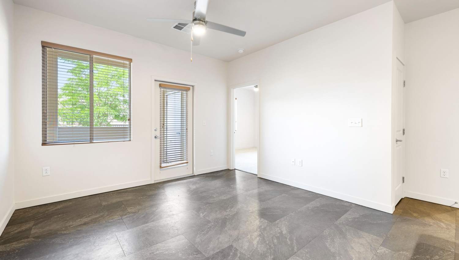 Bedroom with a ceiling fan and a window at Olympus Alameda in Albuquerque, New Mexico