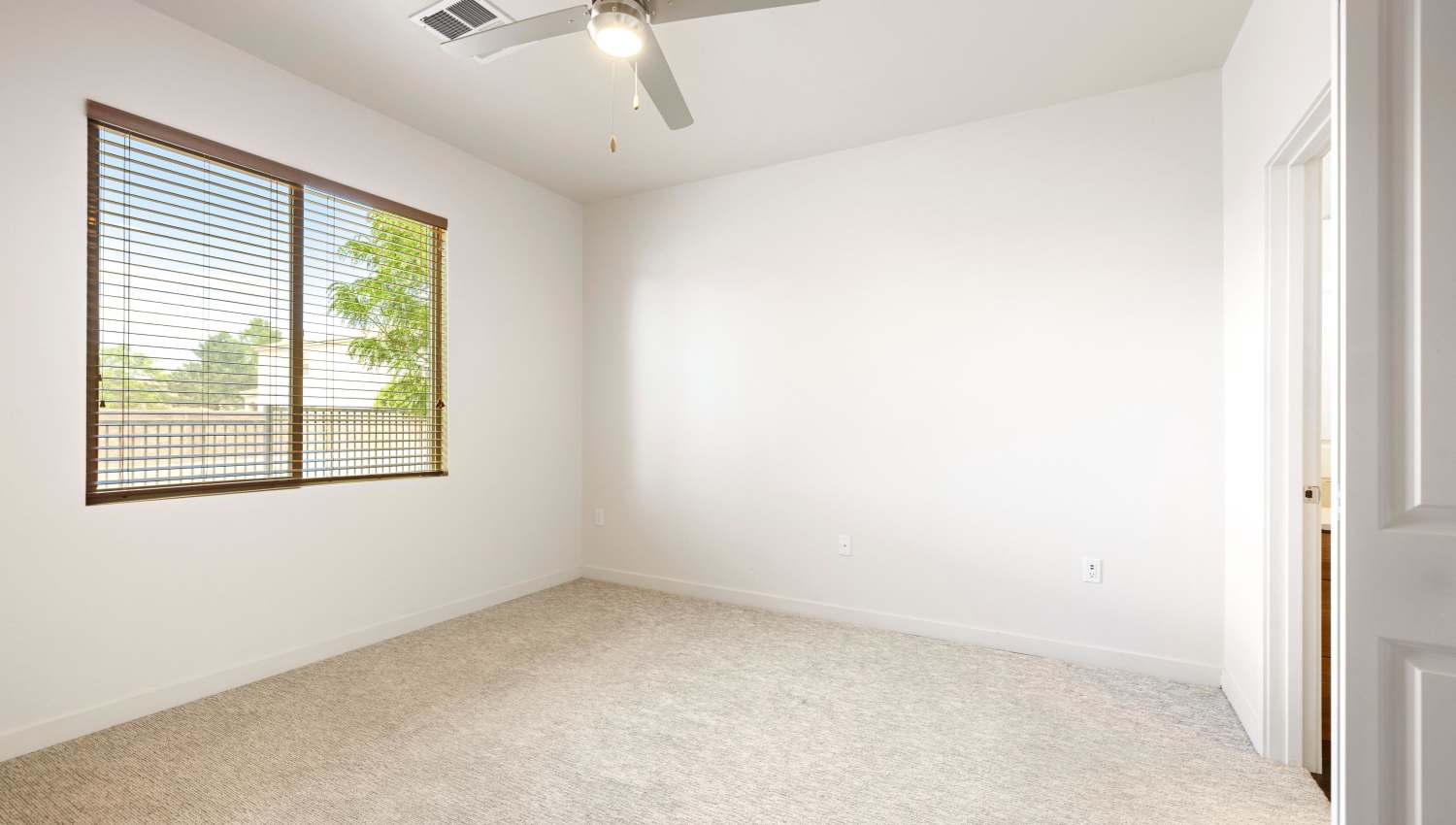 Model bedroom with a fan and a window at Olympus Alameda in Albuquerque, New Mexico
