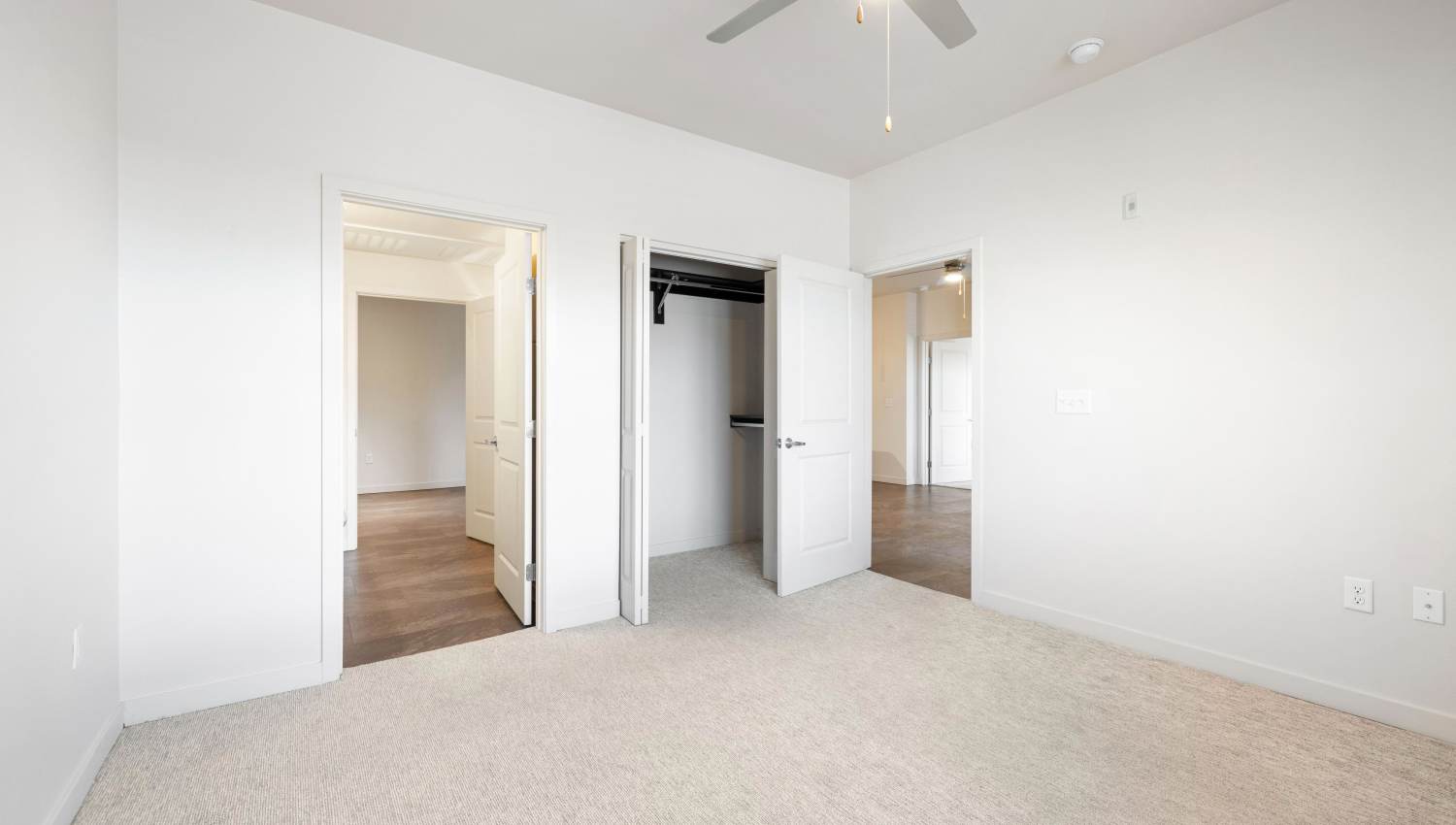 Bedroom with white walls and carpet at Olympus Alameda in Albuquerque, New Mexico