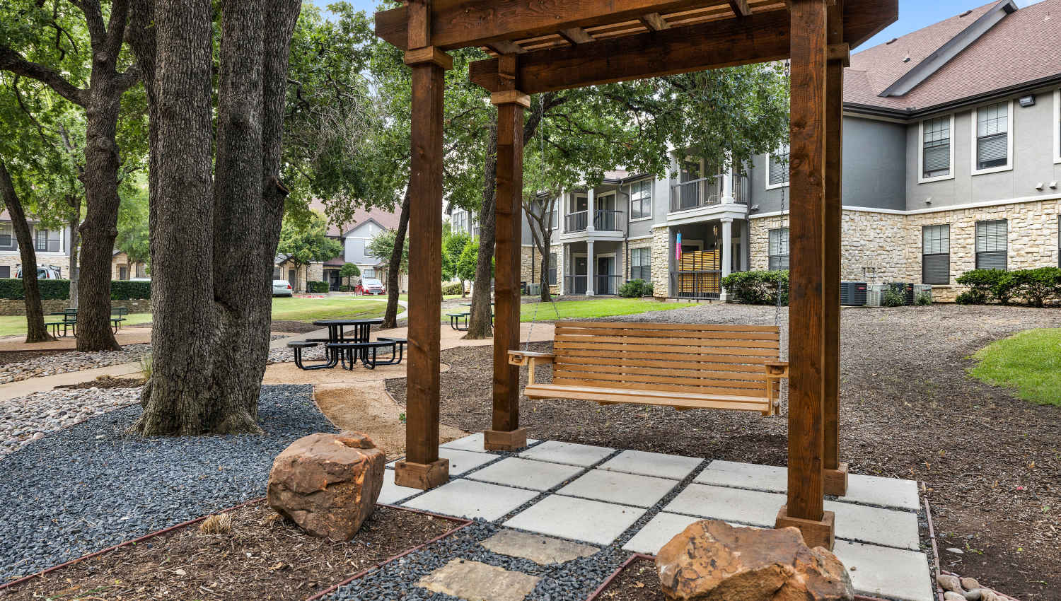 A wooden bench under a canopy at Olympus Town Center in Keller, Texas