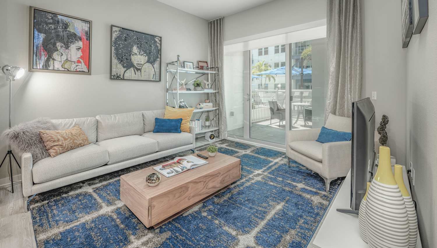 Spacious and well-furnished model home's living area with carpeted floors at 930 Central Flats in St Petersburg, Florida