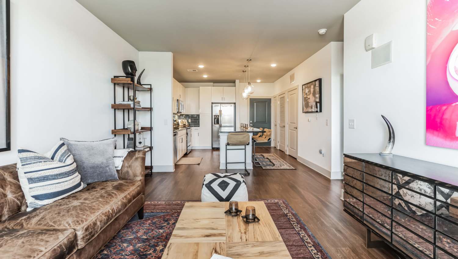 View of kitchen from living room with wood-style flooring at The Griff in Nashville, Tennessee,  