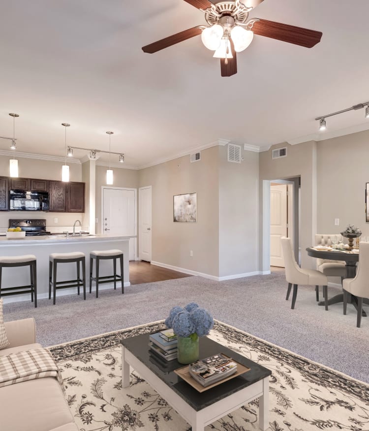 Partial view of the modern kitchen and living area in an open-concept floor plan at Overlook Ranch in Fort Worth, Texas