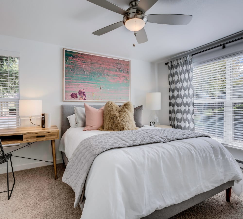 Plush carpeting and a ceiling fan in a standard model home's master bedroom at Centro Apartment Homes in Hillsboro, Oregon