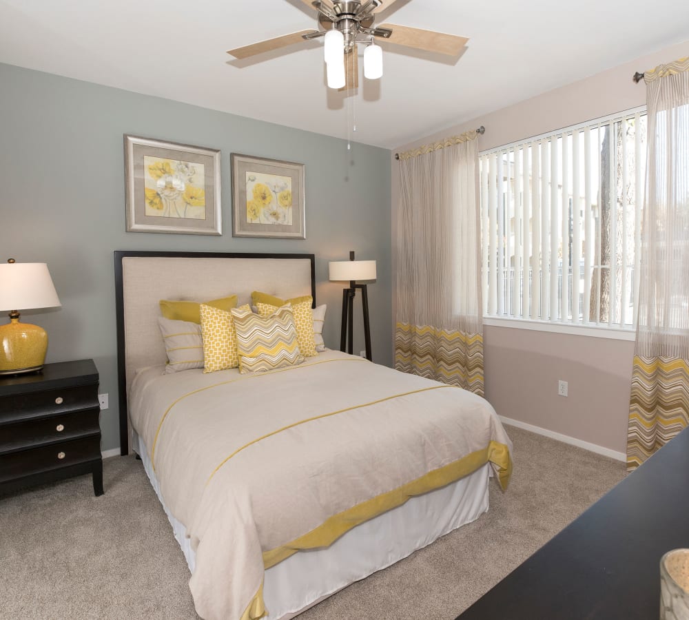 Bedroom with plush carpeting and a ceiling fan at Cross Pointe Apartment Homes in Antioch, California