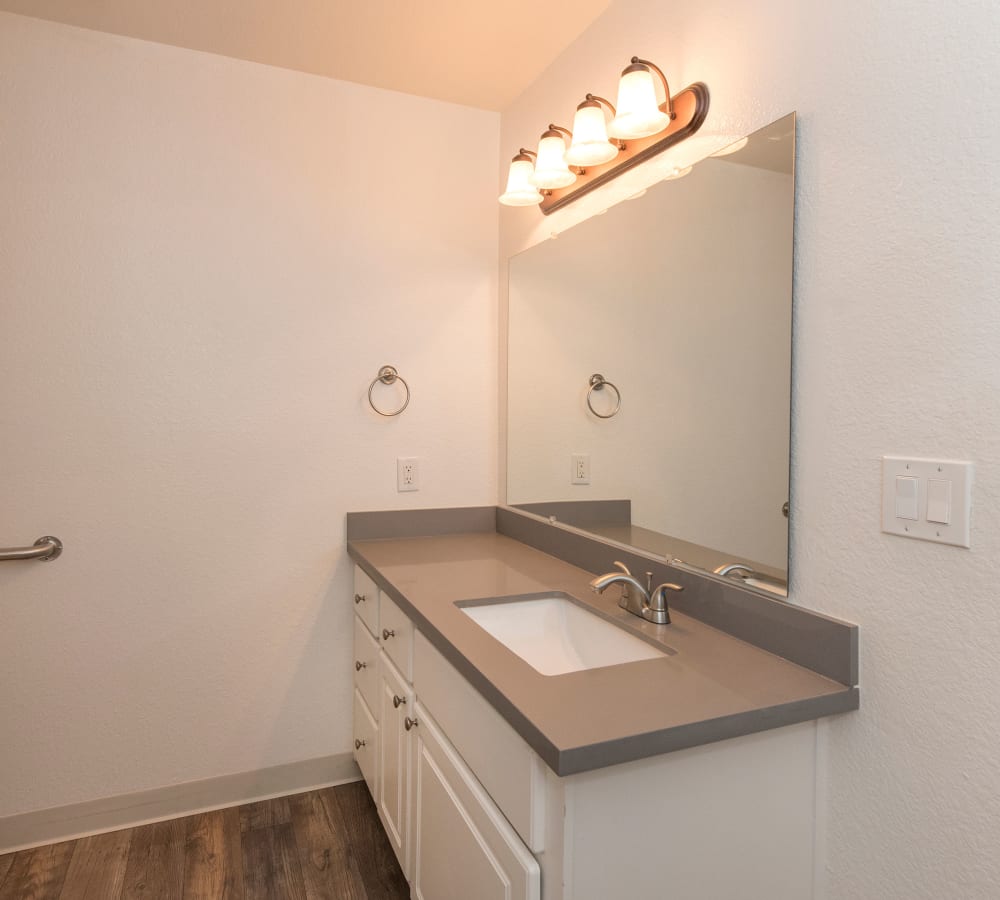 Bathroom with a large vanity mirror at Sterling Heights Apartment Homes in Benicia, California