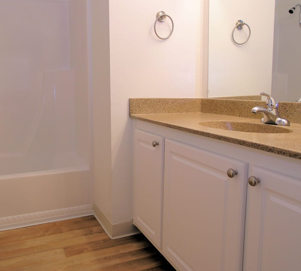 A bathroom with hardwood-style flooring and ample counter space at Villa Palms Apartment Homes in Livermore, California
