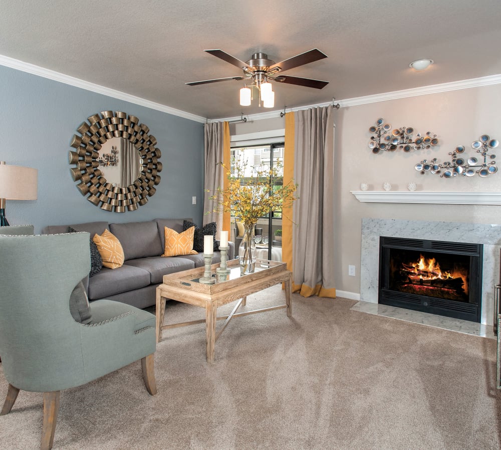 Living room with a fireplace and patio access at The Reserve at Capital Center Apartment Homes in Rancho Cordova, California