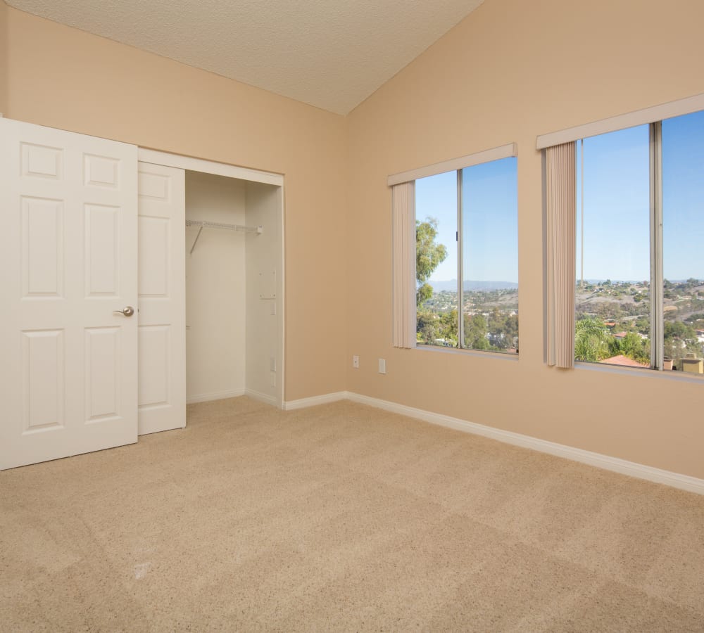 A bedroom with plush carpeting and two large windows at Niguel Summit Condominium Rentals in Laguna Niguel, California