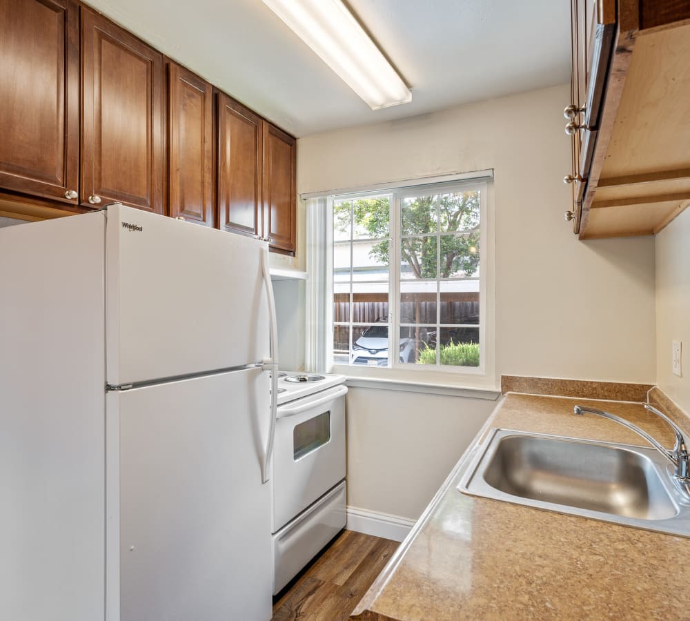 Bright kitchen with wooden cabinetry at Mountain View Apartments in Concord, California